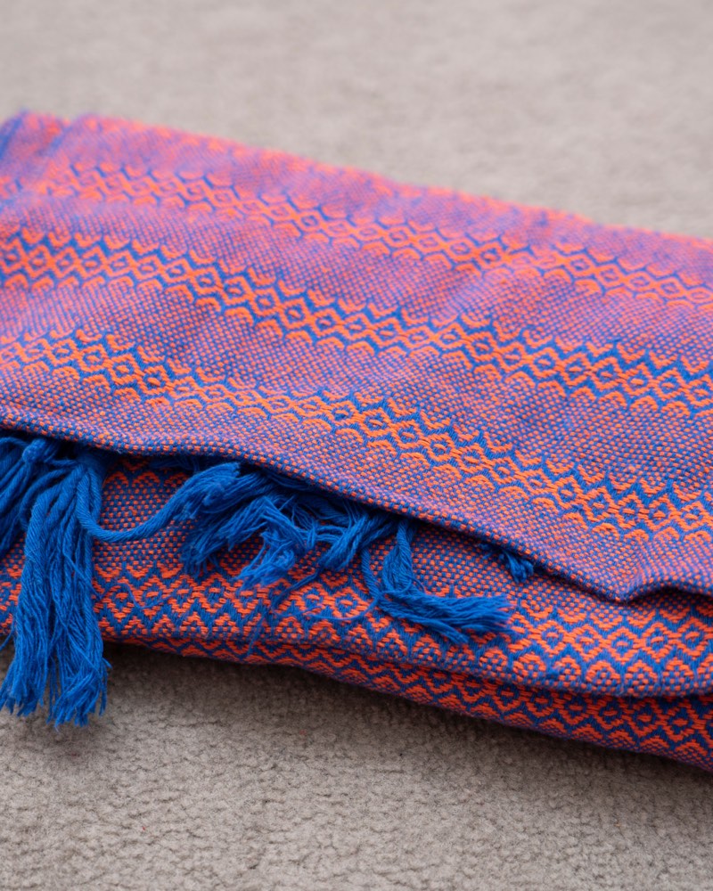 Une étoffe rebozo tissée de motifs bleus et orangés